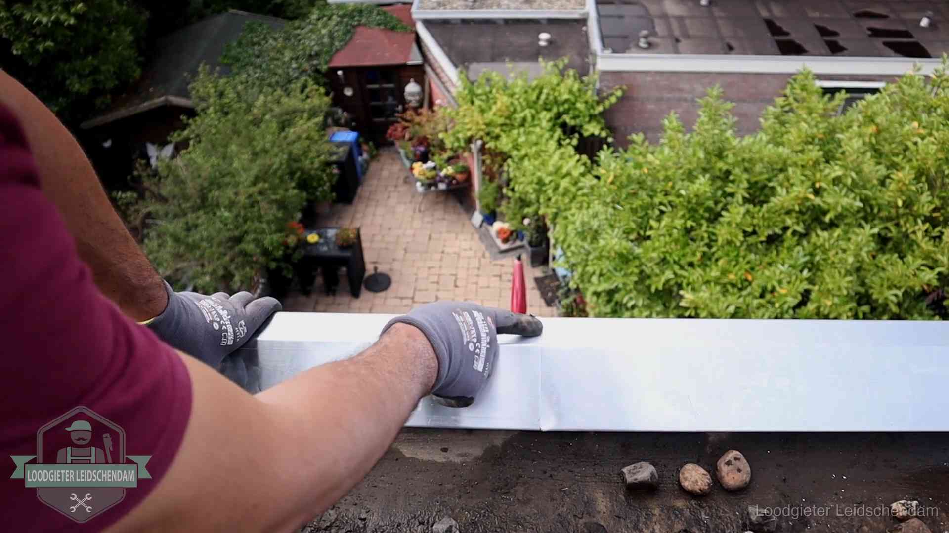Daklekkage geregeld in Leidschendam Vakman plaatst een daktrim op de dakrand van een woning in Leidschendam