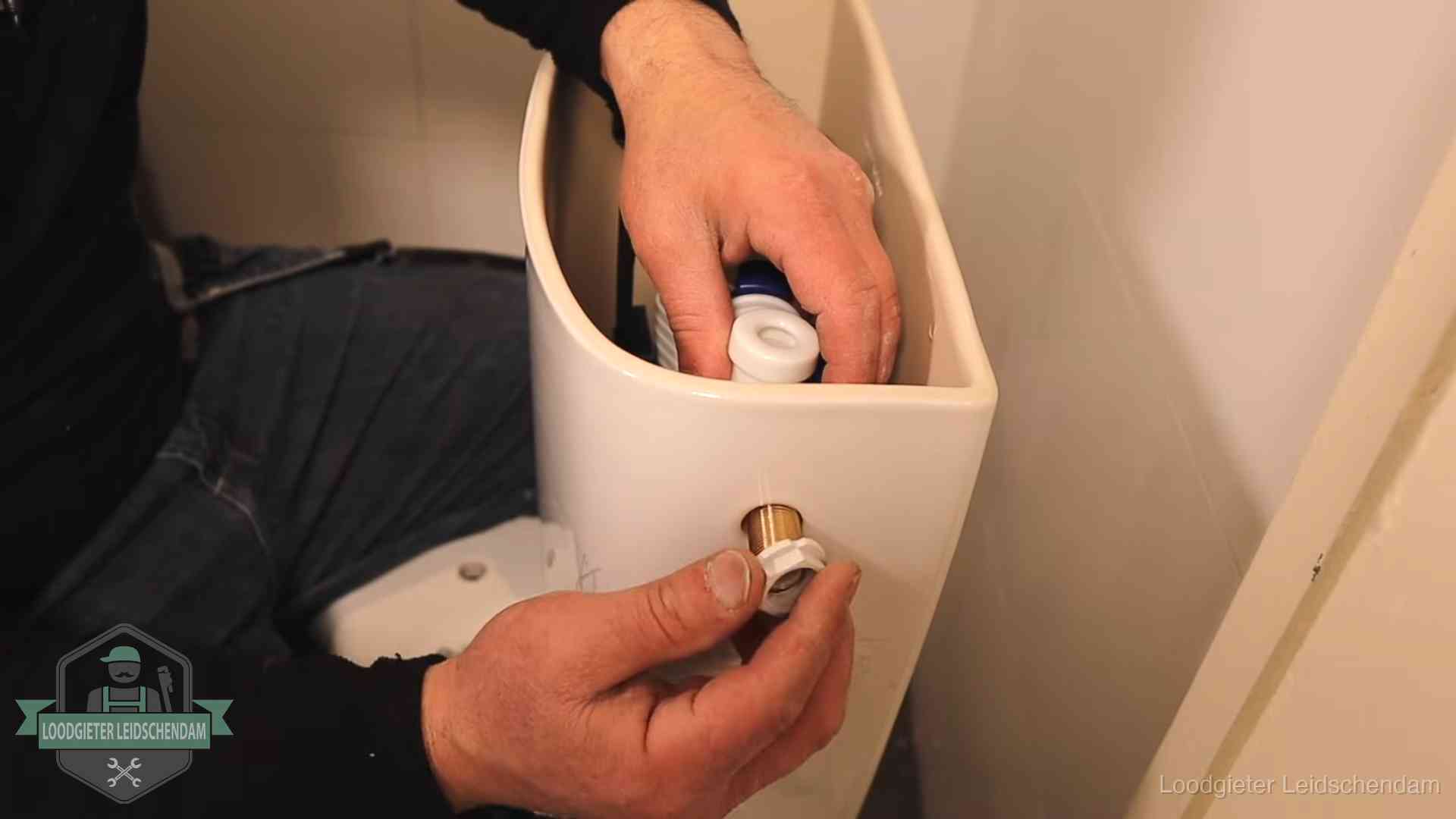 Loodgieter voor je verstopte wc in Leidschendam Loodgieter monteert de vlotterkraan van een stortbak bij een toilet in Leidschendam