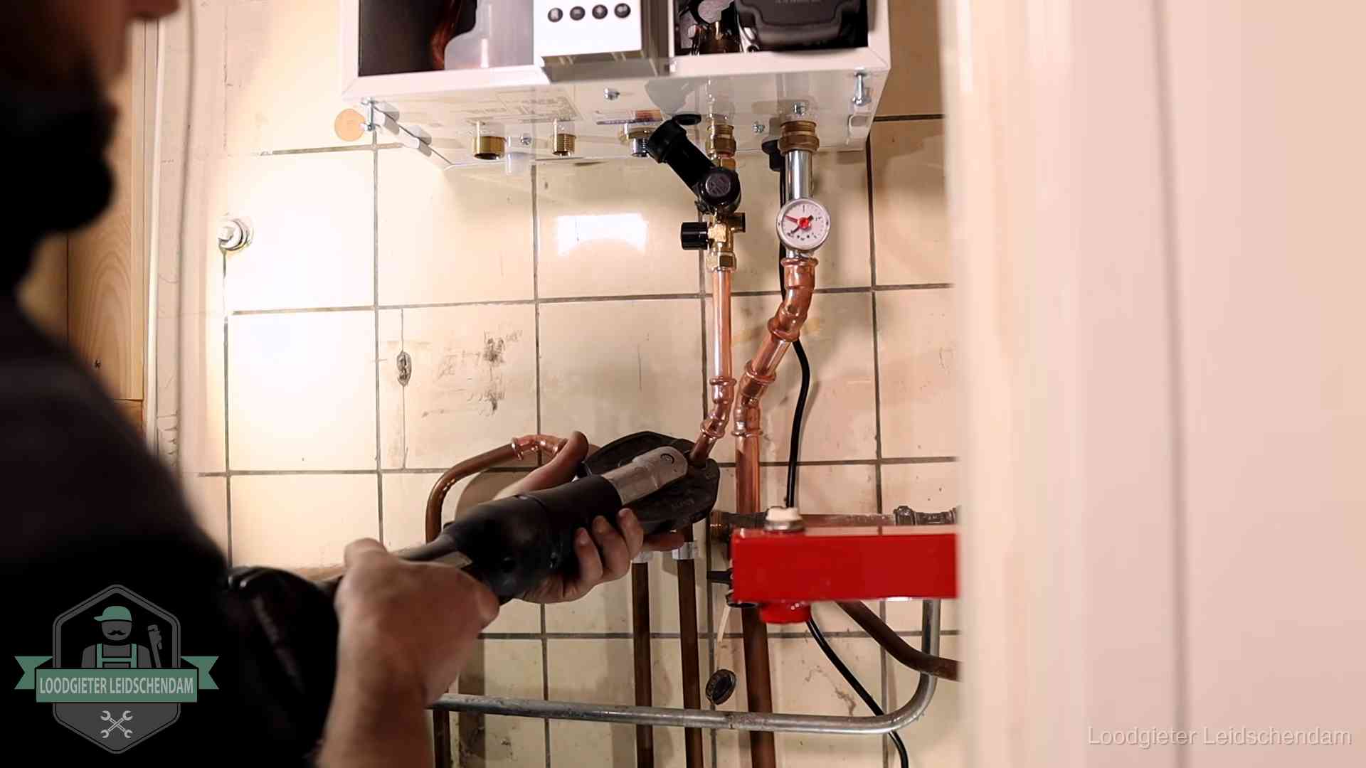 Cv-ketel onderhoud in Leidschendam Monteur werkt aan de leidingen onder een cv-ketel in Leidschendam