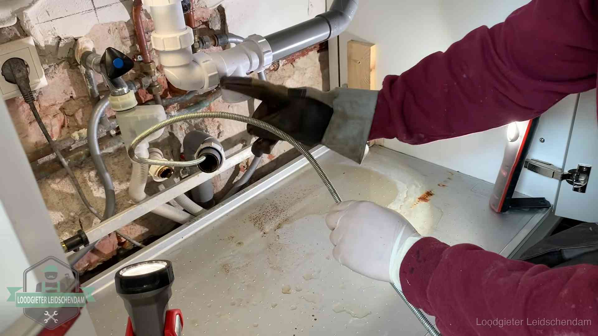 Spiraal of hogedruk in Leidschendam Ontstoppingsveer gaat in een geopende sifonaansluiting onder het aanrecht in Leidschendam