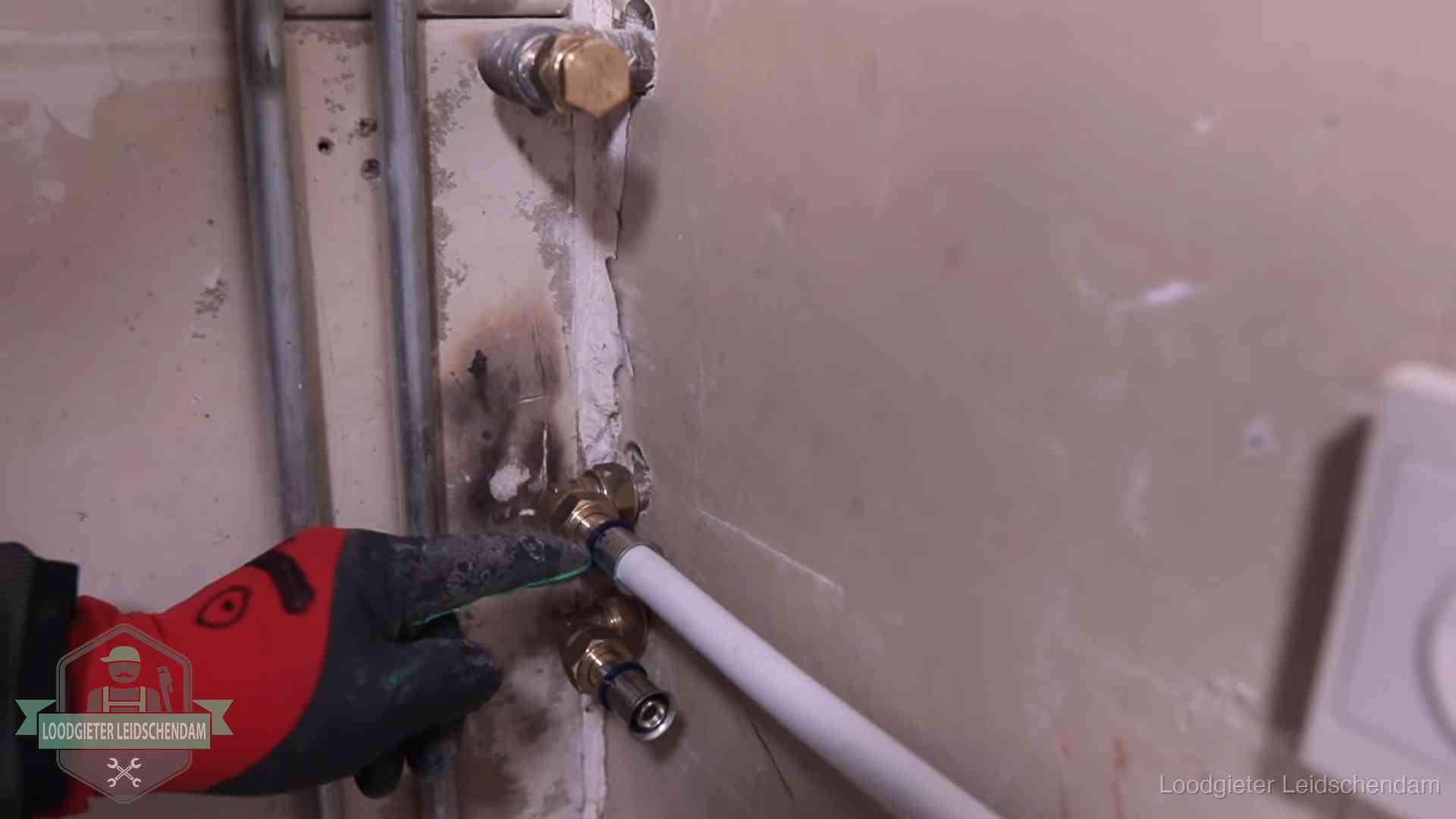 Garantie op loodgieterswerk in Leidschendam Loodgieter wijst de persfitting op nieuwe muuraansluitingen aan in een woning in Leidschendam