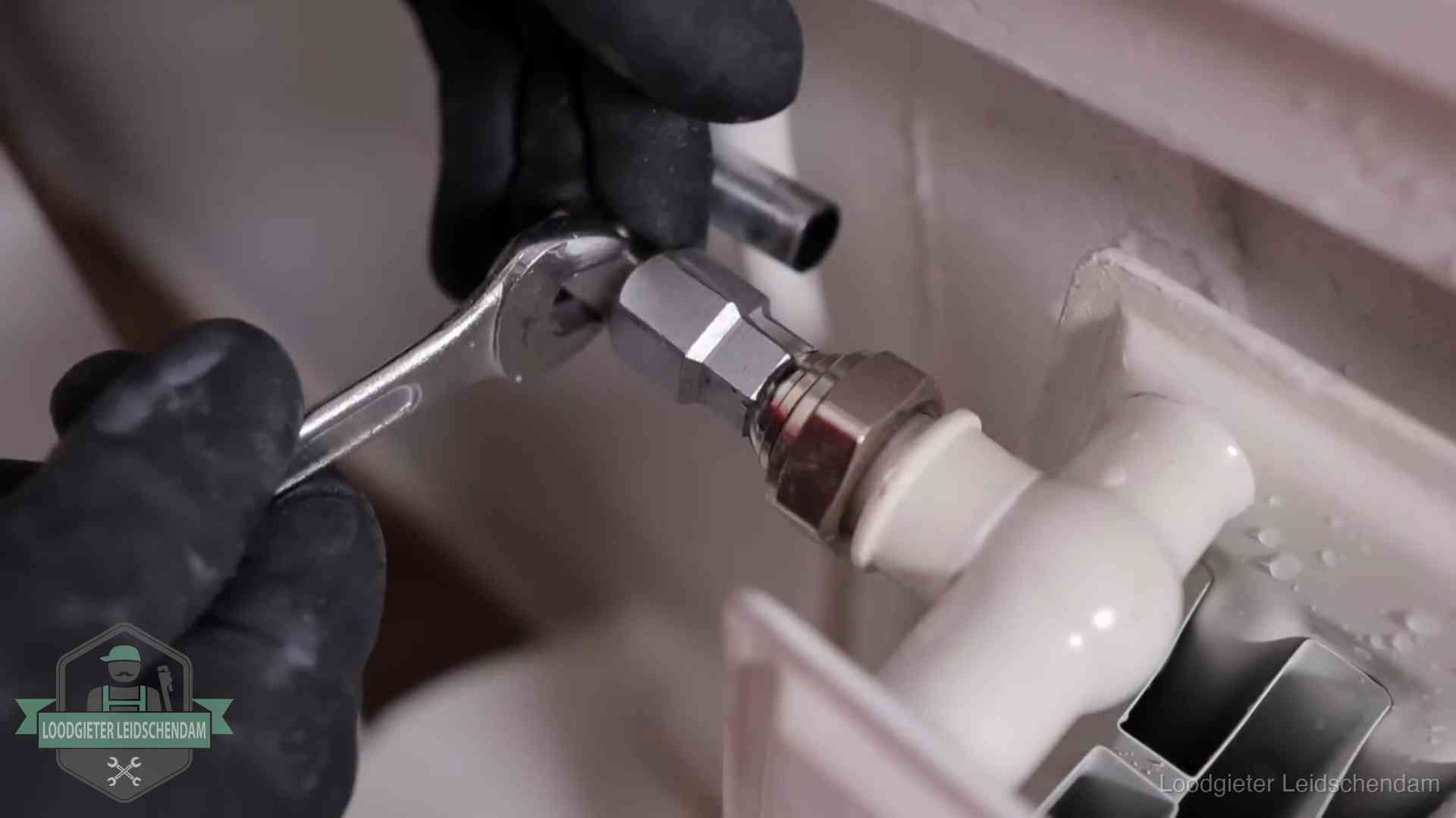 Radiatoren en waterzijdig inregelen in Leidschendam Steeksleutel draait een wartelkoppeling op een radiatorkraan aan in Leidschendam