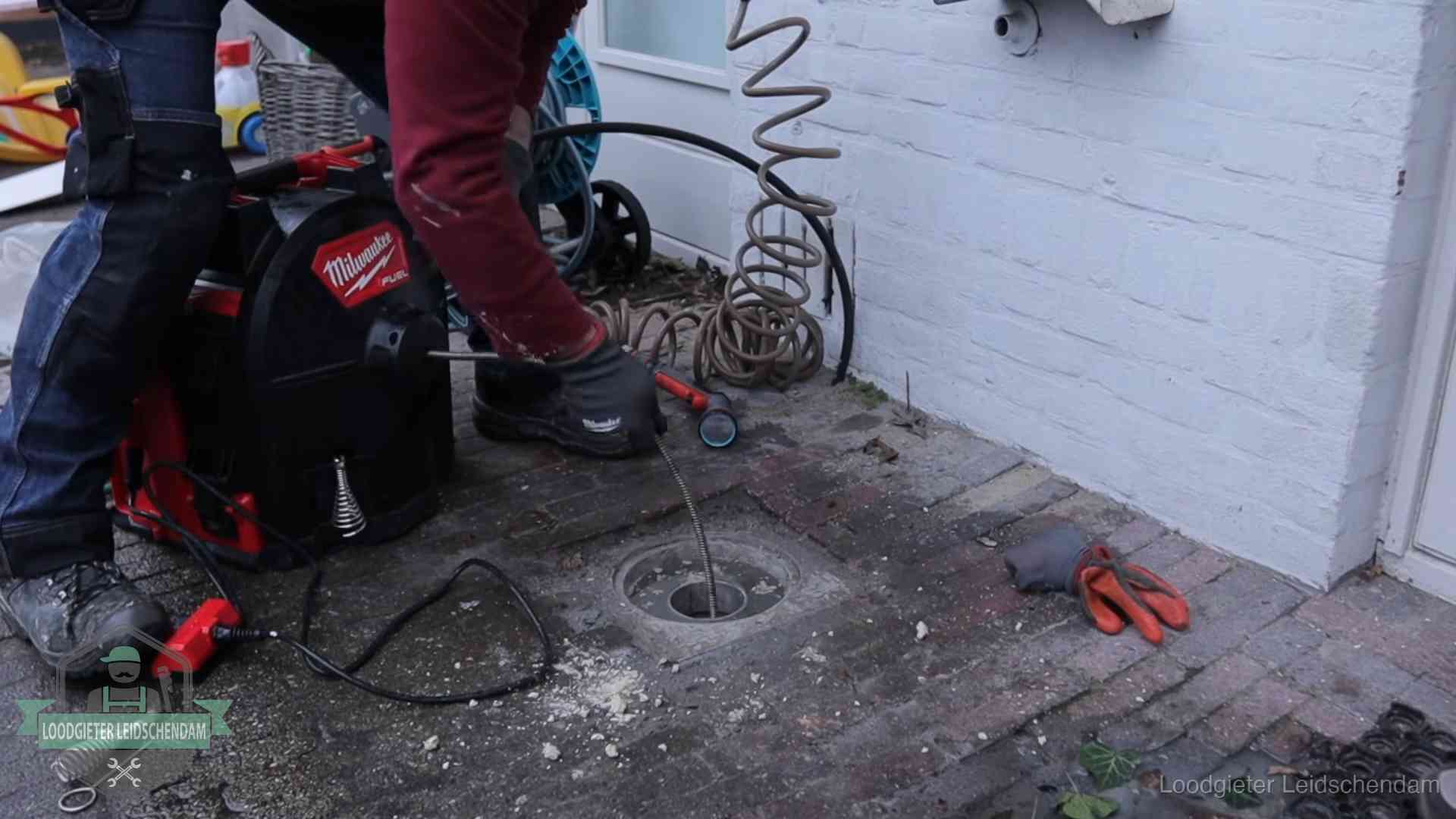 Prijs van een rioolontstopping in Leidschendam Spiraalmachine bij een ontstoppingsputje in de bestrating in Leidschendam