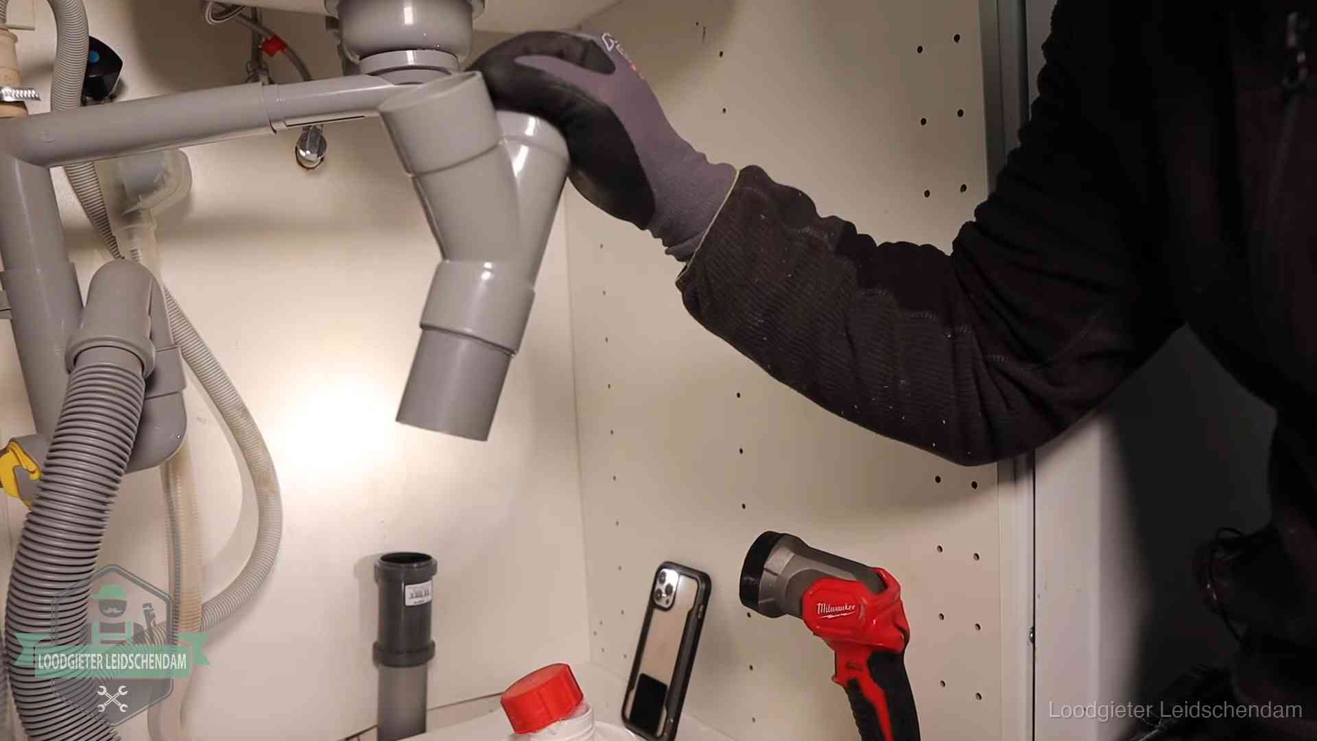Rioollucht in huis verhelpen in Leidschendam Loodgieter demonteert het sifon- en afvoerwerk onder een gootsteen in Leidschendam bij stankklachten