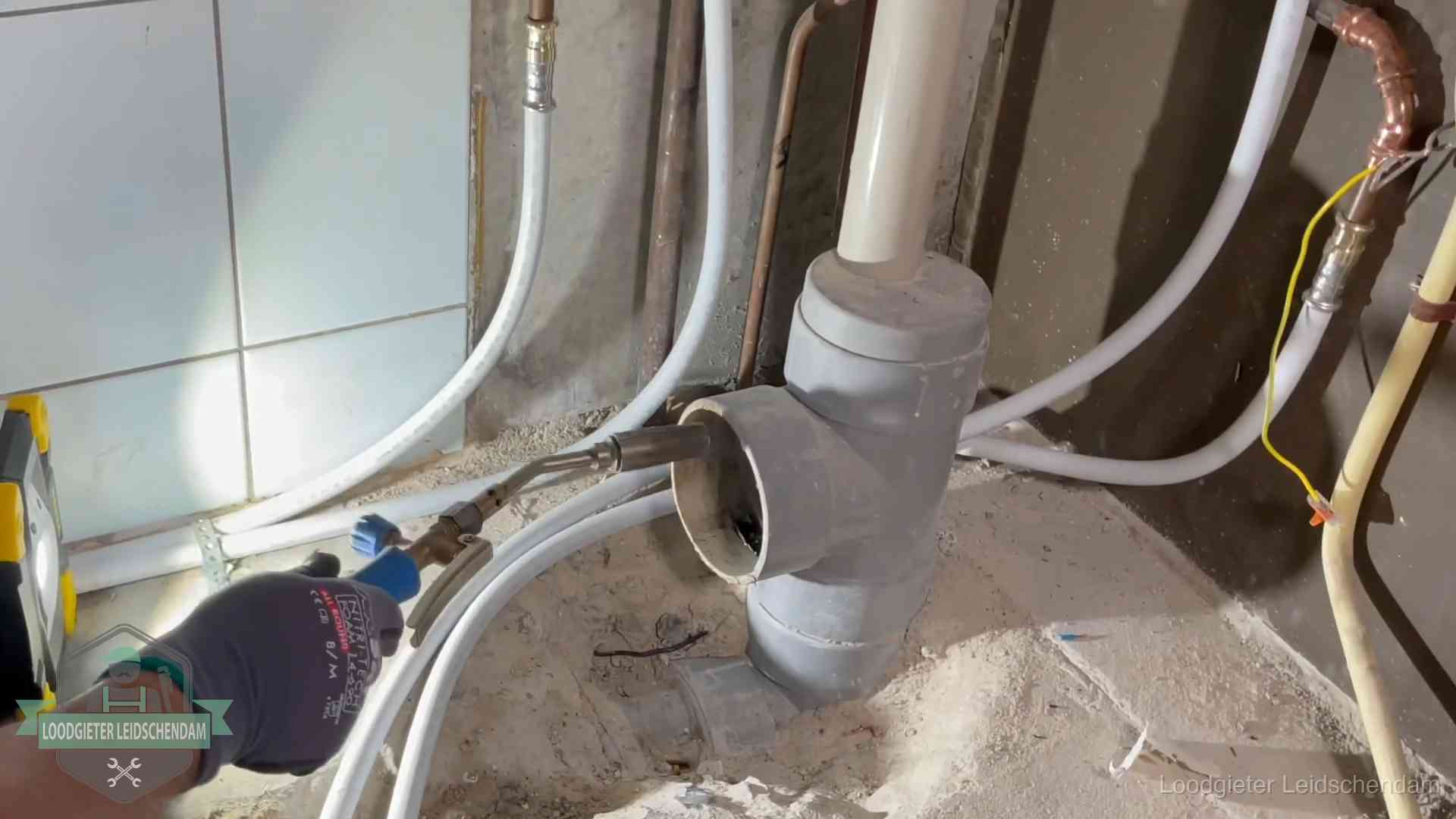 Verstopping in een huurwoning in Leidschendam Loodgieter werkt aan leidingen bij de pvc-standleiding van een huurwoning in Leidschendam