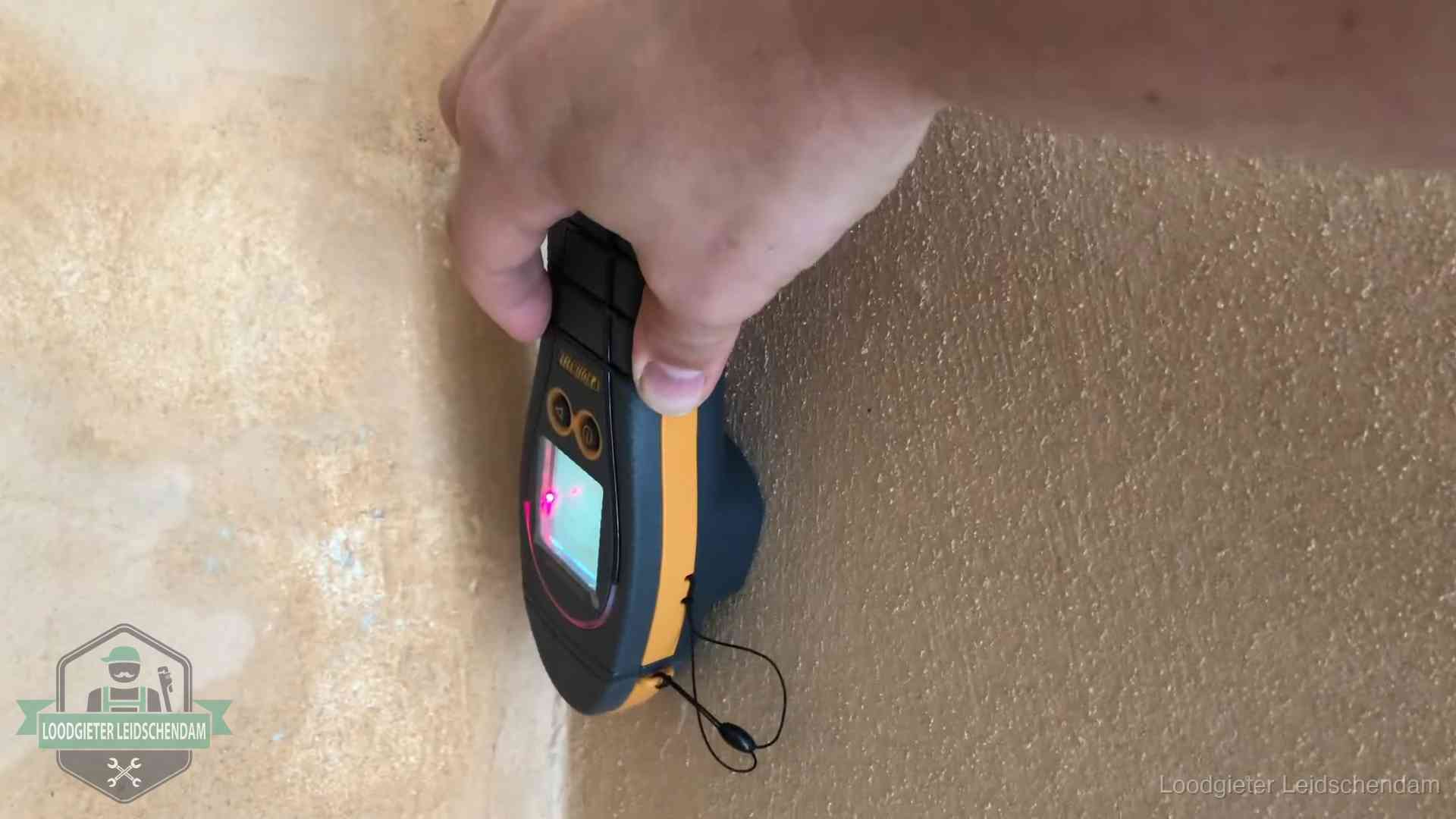 Daklekkage opsporen zonder hakwerk in Leidschendam Vochtmeter tegen een muur met vochtplekken tijdens het opsporen van een daklekkage in Leidschendam