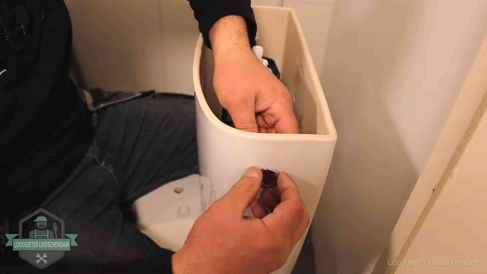 Je wc verstoppingsvrij houden in Leidschendam Drukknop van een duoblok-stortbak wordt gemonteerd bij een toilet in Leidschendam