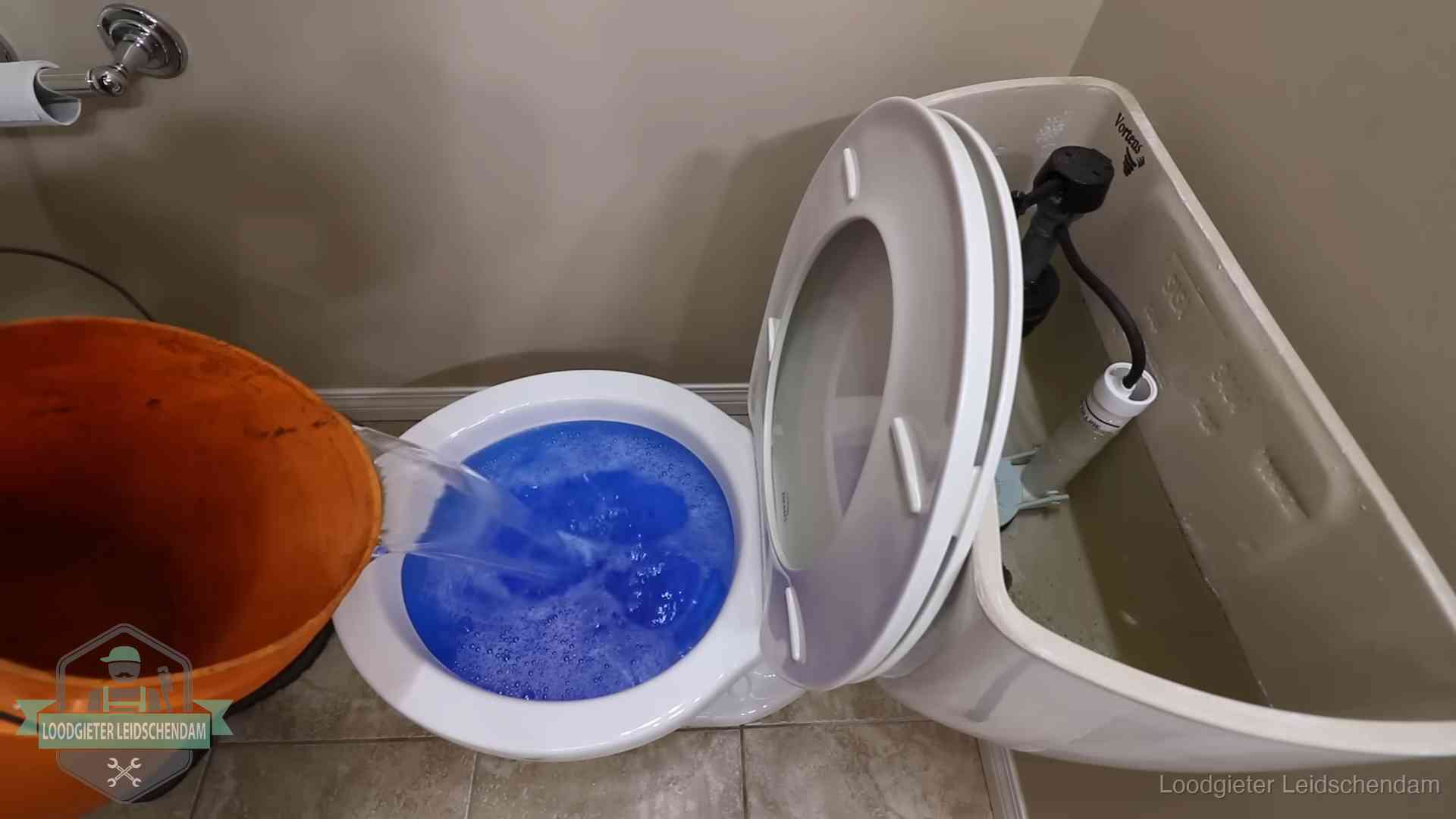 Water komt omhoog in de wc in Leidschendam Water bij de wc-pot wordt met een emmer weggewerkt om schade te beperken in Leidschendam